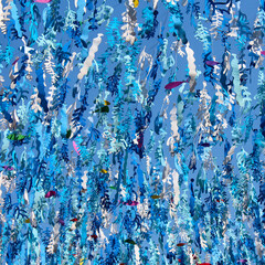 Plastic seaweed and fish garlands on blue sky background