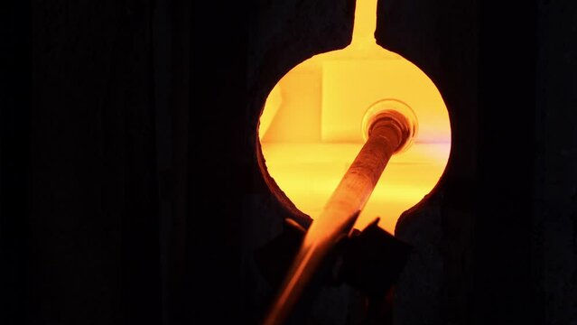 artesano hace botella de vidrio en horno