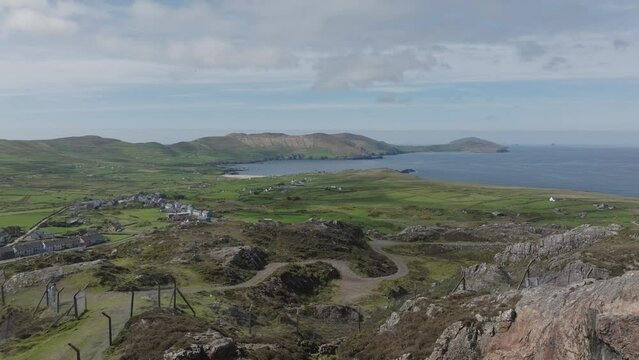 Drone establishing shot flying over old Coppermine workings to Allihies village and the sea at west Cork Ireland on a warm May morning