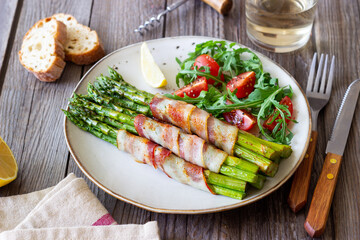 Asparagus baked with bacon and arugula and tomato salad. Healthy eating. Diet.