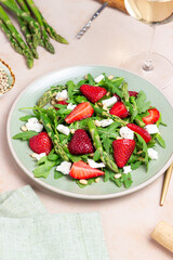Salad with strawberries, asparagus, arugula, white cheese and nuts. Healthy eating. Vegetarian food.