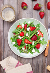 Salad with strawberries, asparagus, arugula, white cheese and nuts. Healthy eating. Vegetarian food.