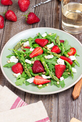 Salad with strawberries, asparagus, arugula, white cheese and nuts. Healthy eating. Vegetarian food.
