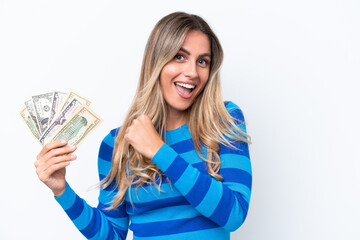 Young Uruguayan woman taking a lot of money isolated on white background celebrating a victory