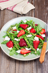 Salad with strawberries, asparagus, arugula, white cheese and nuts. Healthy eating. Vegetarian food.