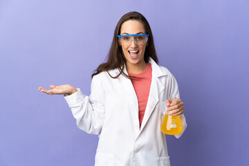 Young scientific woman over isolated background with shocked facial expression