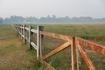 Horse farm with old wooden fence on dry pasture of natural landscape