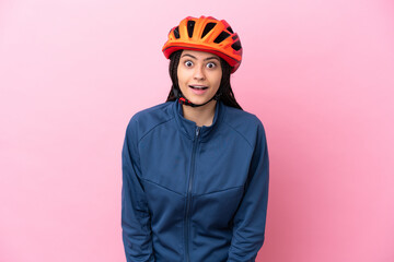 Teenager cyclist girl isolated on pink background with surprise facial expression