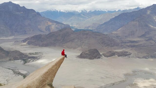 A tourist man climbing Marsur Rock cliff in Karakoram high mountain hills. Nature landscape background, Skardu-Gilgit, Pakistan. Travel on holiday vacation. People lifestyle