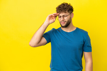 Fototapeta na wymiar Young handsome caucasian man isolated on yellow background with tired and sick expression