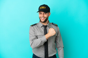 Young security man isolated on blue background celebrating a victory