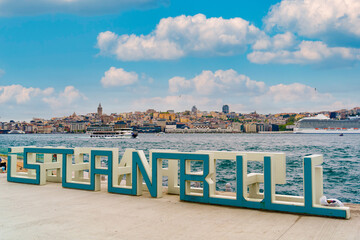 Istanbul city sign monument is seen on sunny day with cityscape in the background over the Bosphorus channel. Symbol of Istanbul