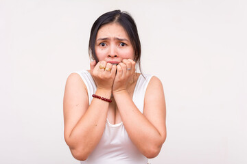 A scared and nervous young Asian woman biting her fingernails in terror. Isolated on a white...