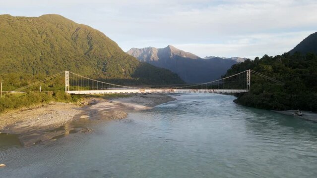 Aerial pedestal of picturesque river bridge in lush mountainous region