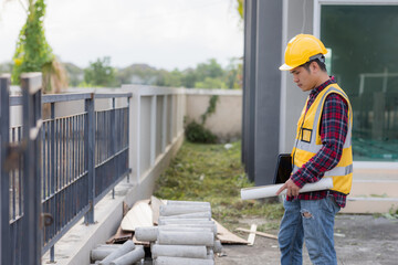 A construction engineer is using a tablet to inspect a construction project on the background of a construction site.