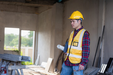 Male civil engineer in safety clothes using digital tablet to inspect work and quality control for construction contractor and real estate developer