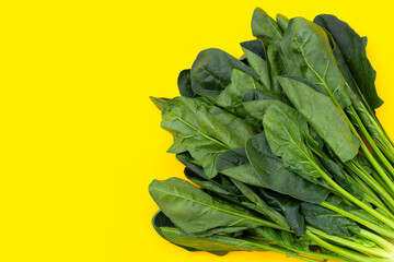 Fresh spinach on yellow background