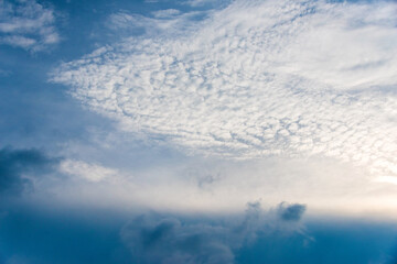 Scattered cloud clusters in a blue sky, blue sky background with white clouds.