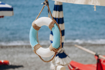 Decorative lifebuoy on the beach in Italy, on the Italian Riviera.