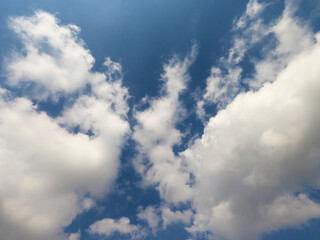 Scattered cloud clusters in a blue sky, blue sky background with white clouds.