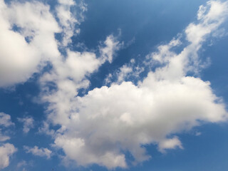 Scattered cloud clusters in a blue sky, blue sky background with white clouds.