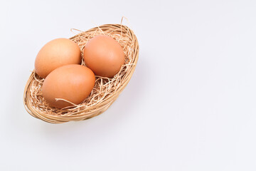 Three Brown Eggs in Rattan Basket Slant