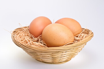 Three Brown Eggs in Rattan Basket