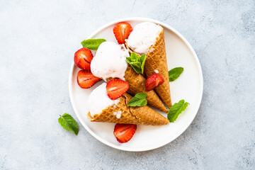Homemade ice cream with fresh strawberries on stone table. Flat lay.