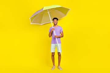 Full length photo of young tourist man wear stylish outfit blue shorts purple t-shirt hold parasol...