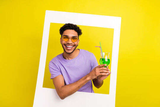 Portrait of carefree positive person hands hold cocktail glass paper album card window isolated on yellow color background