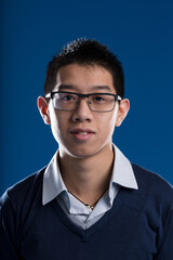 Mugshot of a young Asian man with glasses and a disheveled shirt