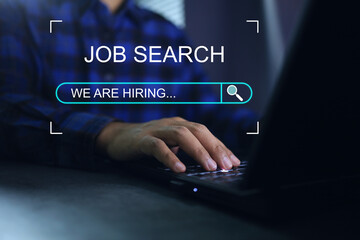 Working man use laptop to find a job or job search and job finding work on dark background we are hiring concept.