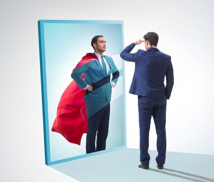 Businessman seeing himself in mirror as superhero