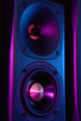 Multimedia acoustic sound speaker with neon lighting. Sound audio system on dark background.