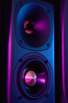 Multimedia acoustic sound speaker with neon lighting. Sound audio system on dark background.