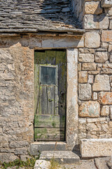 Typical old house with weathered doors and stone wall, Rogoznica village, Dalmatia, Croatia