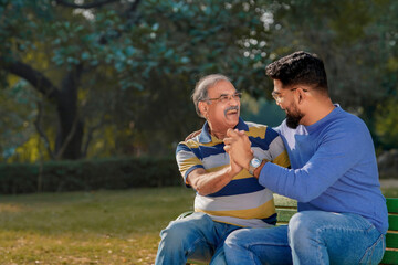 Fototapeta premium Old indian father with his young son spending time at park.