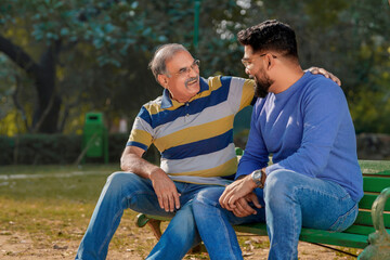 Fototapeta premium Old indian father with his young son spending time at park.