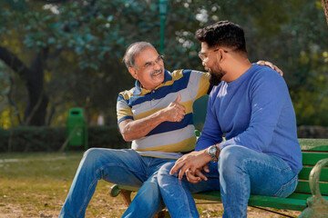 Fototapeta premium Old indian father with his young son spending time at park.
