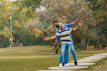Naklejka premium Old indian father with his young son spending time at park.