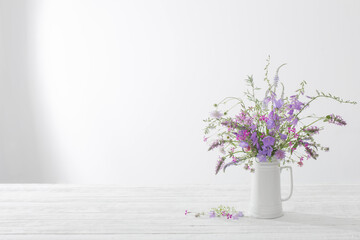 summer wild  flowers  in white jug on white background