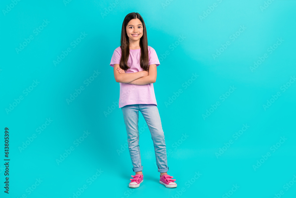 Wall mural full body cadre of small preteen schoolgirl folded arms smiling wear denim jeans pink t-shirt sneake