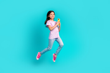 Fototapeta na wymiar Full length body size photo of small funky girl jump hold smartphone wifi connection playing gadget games isolated on blue color background