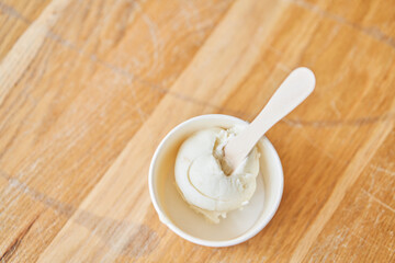 Vanilla ice-cream in disposable cups on the table. Italian gelateria. Natural fresh gelato. 