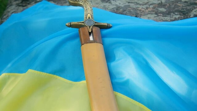 The saber of the Ukrainian Cossacks lies on the flag of Ukraine. Close-up.