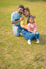 Naklejka na ściany i meble Happy indian couple with his little girl at garden.