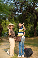 Smiling indian senior couple with suitcases,Summer vacation, traveling concept.