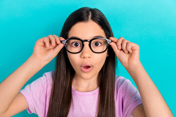 Photo of sweet impressed little child dressed pink t-shirt arms eyewear big eyes isolated teal color background