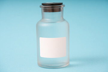 transparent glass bottle for chemical or biological substances on a blue background