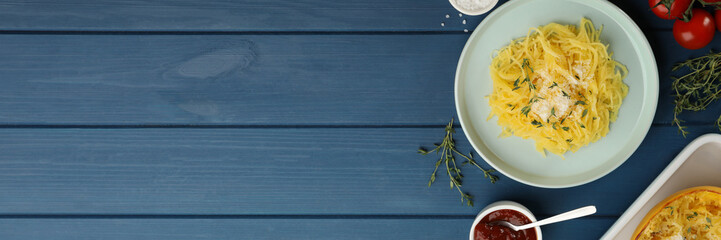 Tasty spaghetti squash with cheese and thyme served on blue wooden table, flat lay. Banner design with space for text